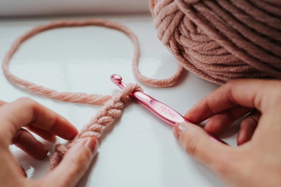  A person crochets with their hands.