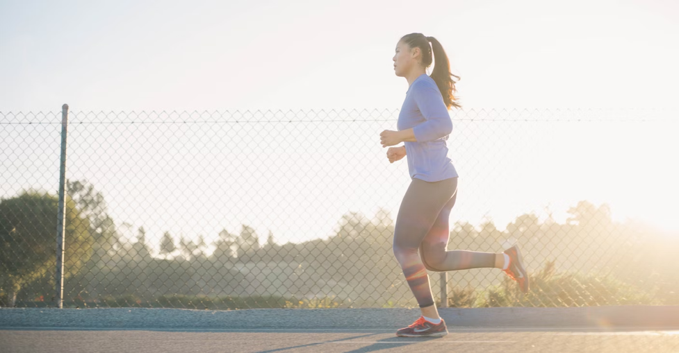 A woman runs outdoors.